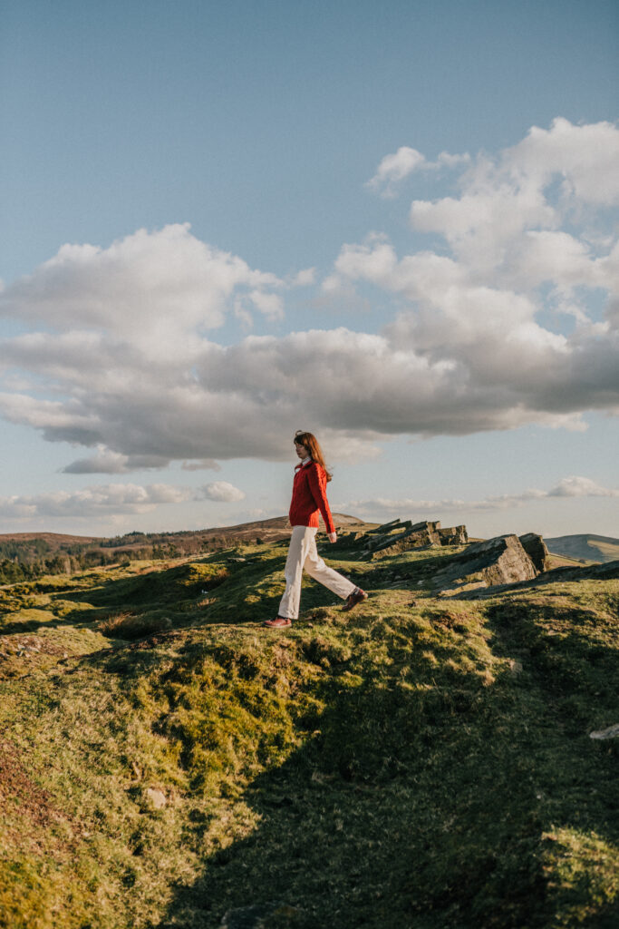 woman walking on the hills in red sweater